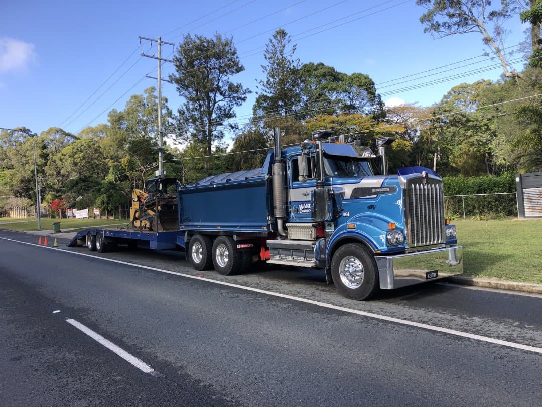 Ward Excavation Kenworth dump truck with flatbed trailer and CAT excavator on board, at the Whiteville yard.