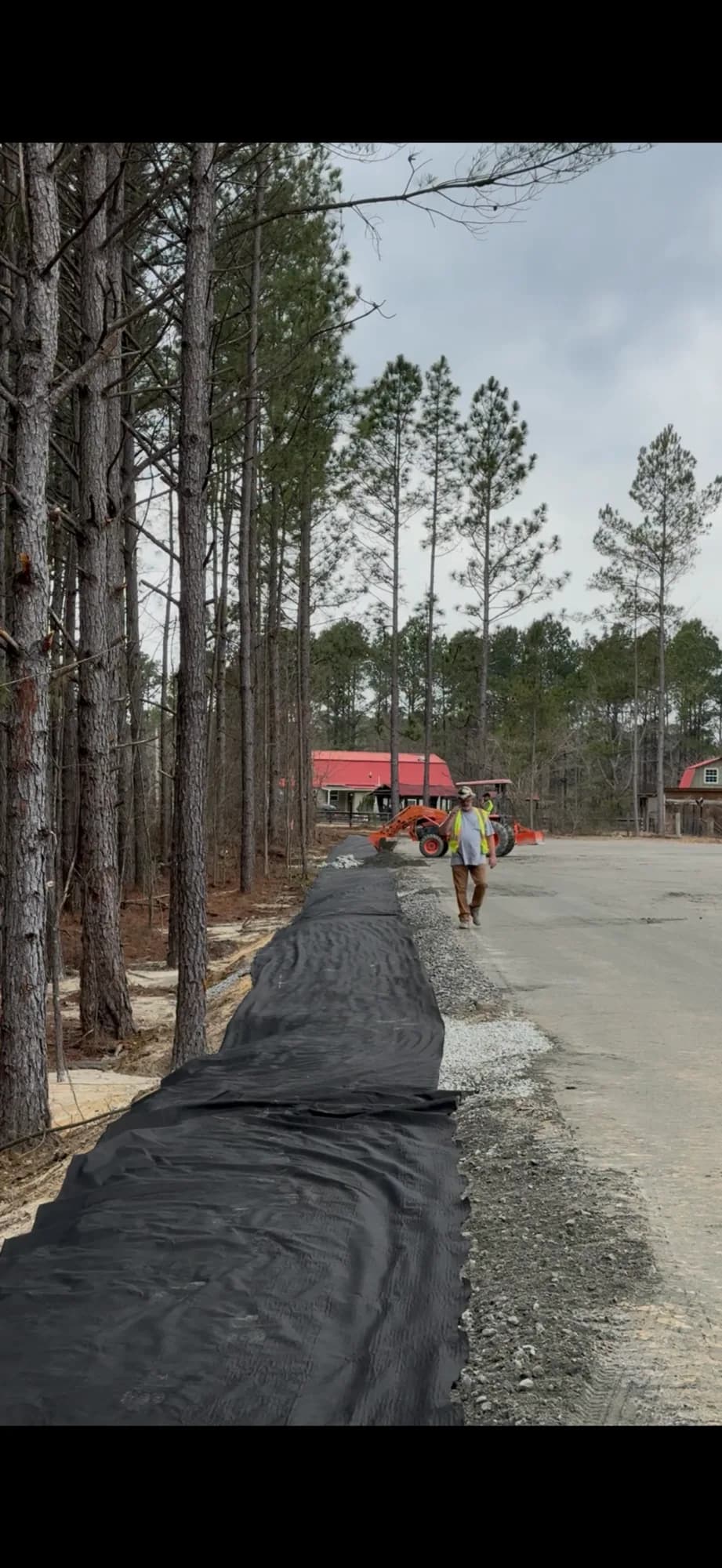 Silt-fence sediment-control barrier installed alongside a graded dirt road at a Ward Excavation site.