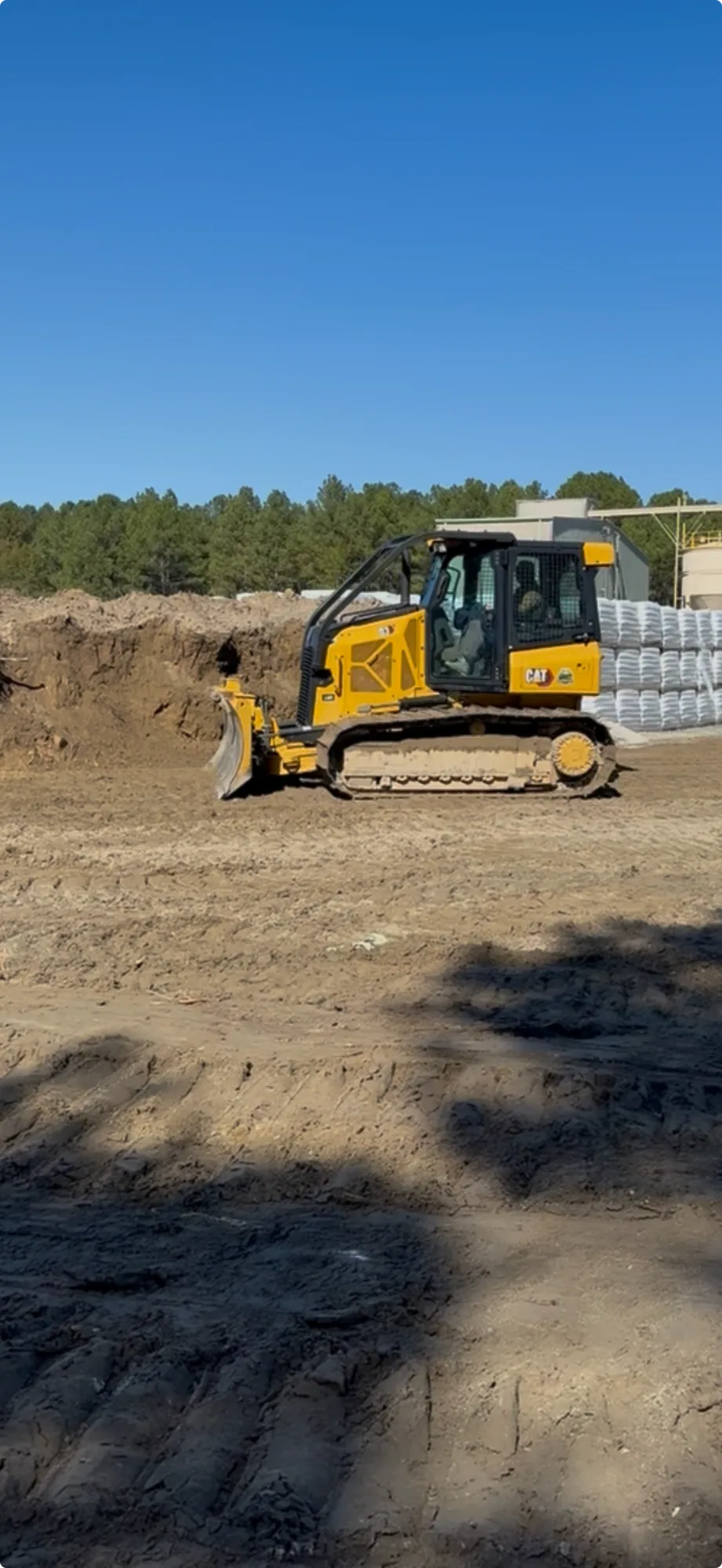 Ward Excavation CAT dozer grading a building pad under a clear blue Carolinas sky.
