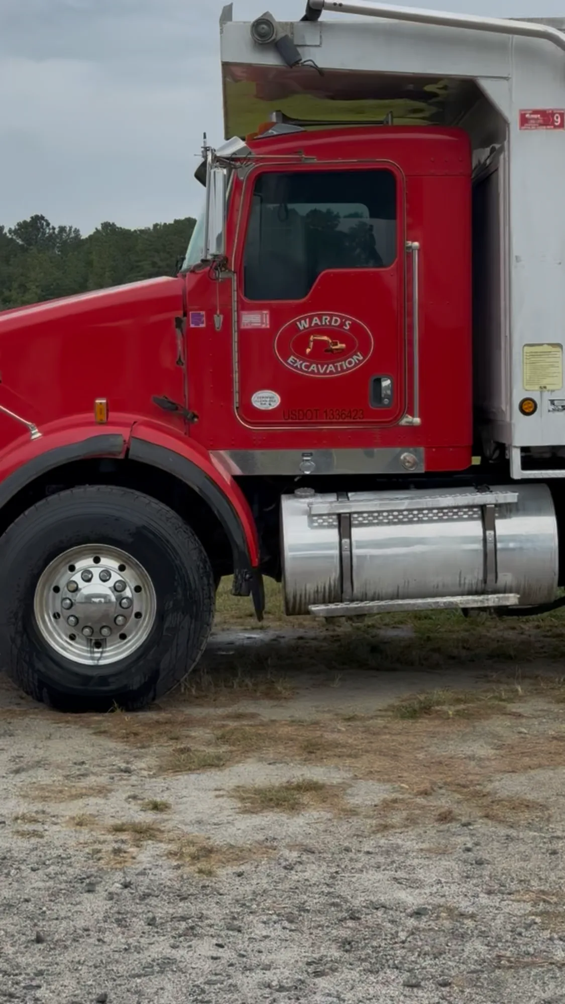 Ward's Excavation branded red Kenworth triaxle dump truck parked at a Carolinas jobsite.